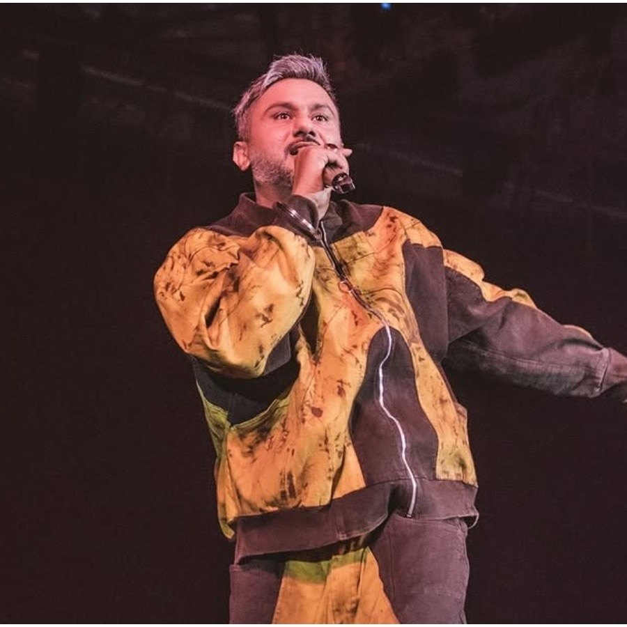 A live performance in a yellow-and-black jacket.